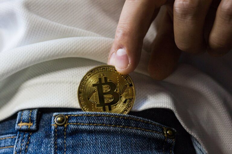 A man putting a Bitcoin into his pocket