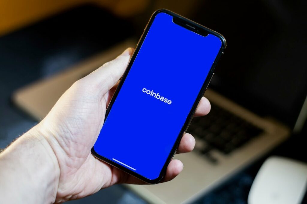 Alt text - A person holding a phone with an open Coinbase app