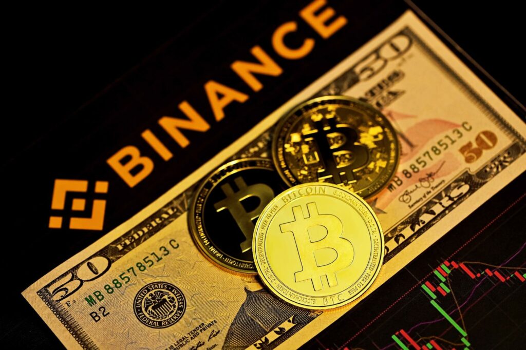 Binance logo next to some Bitcoins