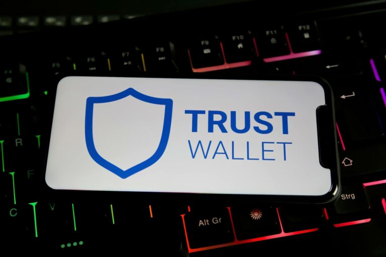 Trust Wallet app on a smartphone placed over a keyboard
