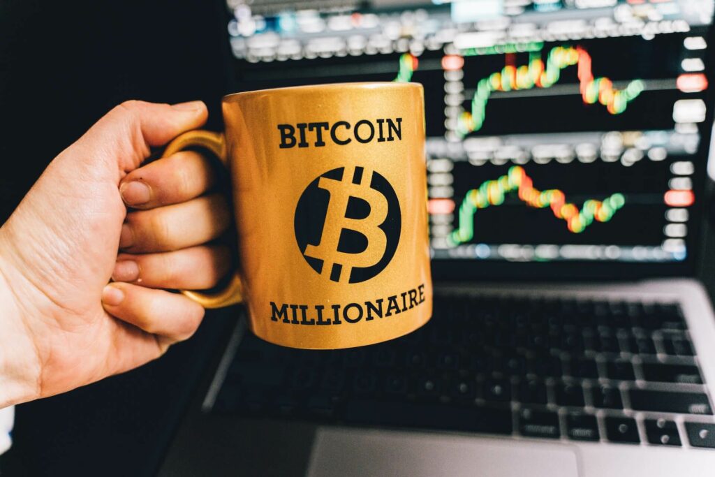 Person holding a mug with a Bitcoin millionaire print